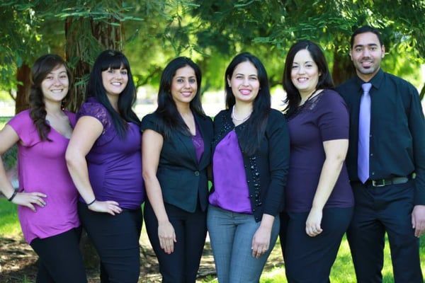 A group of people posing for a picture in front of trees