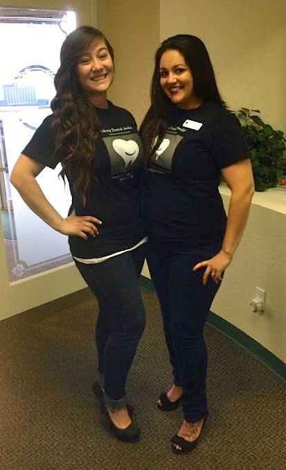 Two women are standing next to each other in a room.