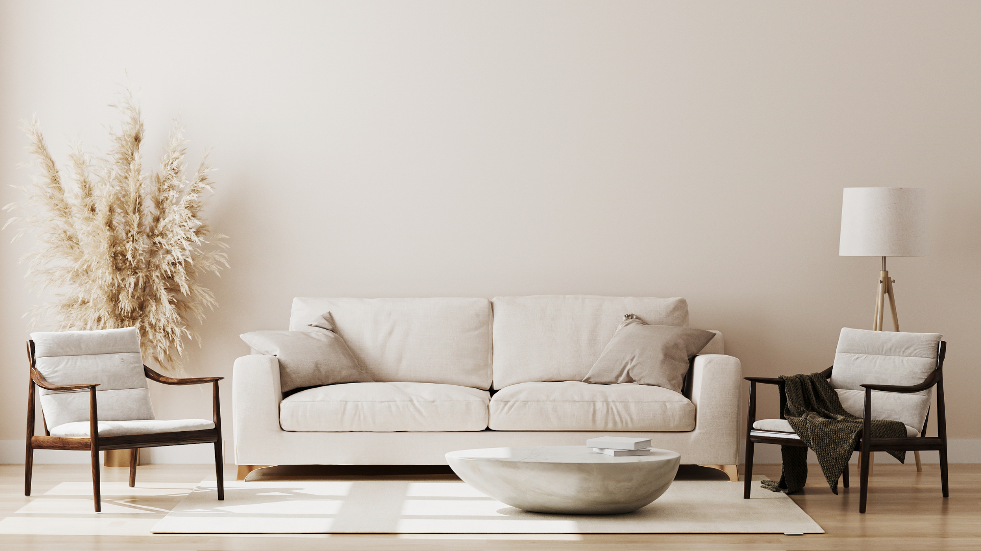 Minimal beige living room with two armchairs, sofa, floor lamp, dried plants, and a round coffee table