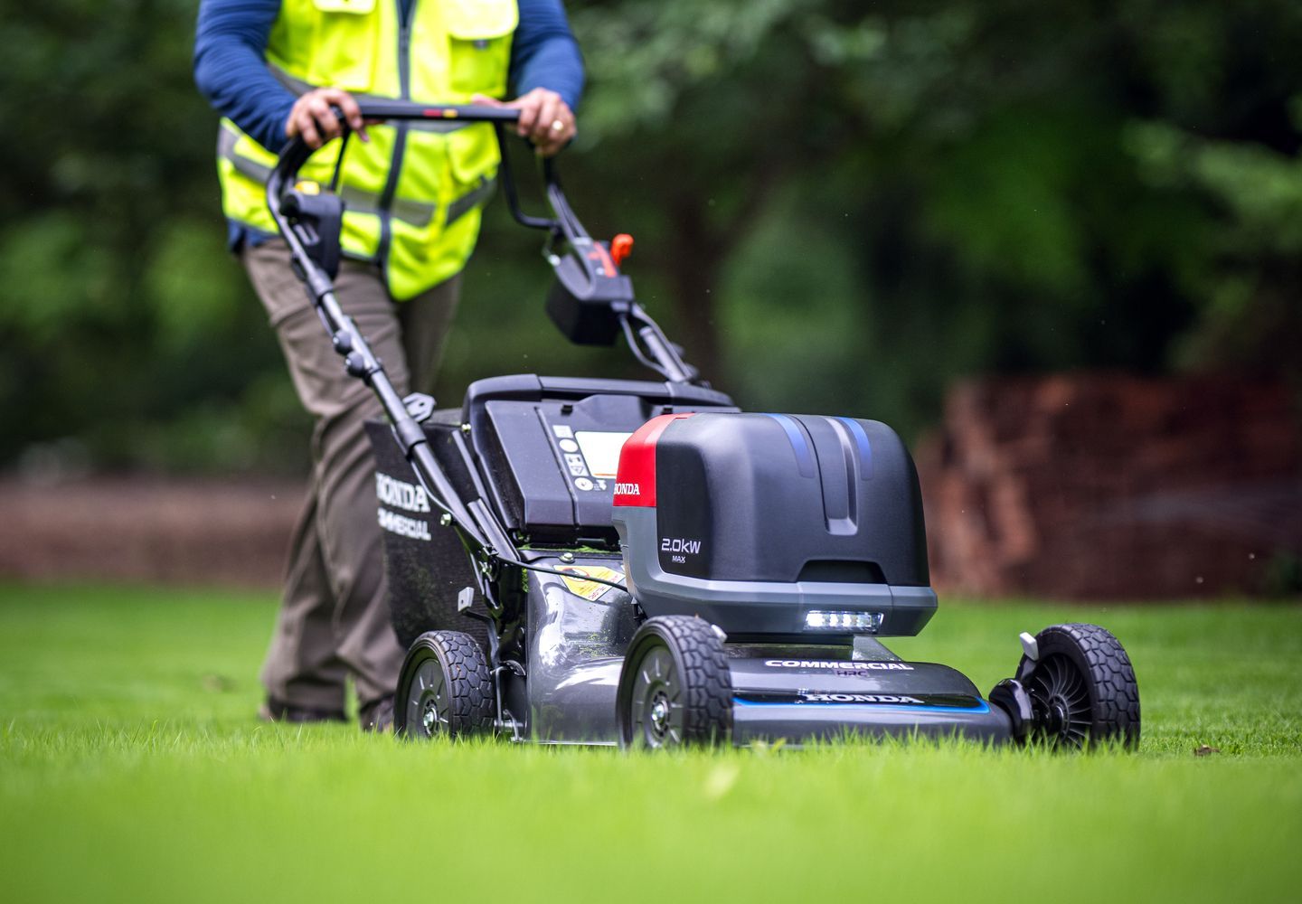 Person Mowing a Grassy Lawn — Great Lakes Mowers & Chainsaws In Forster, NSW