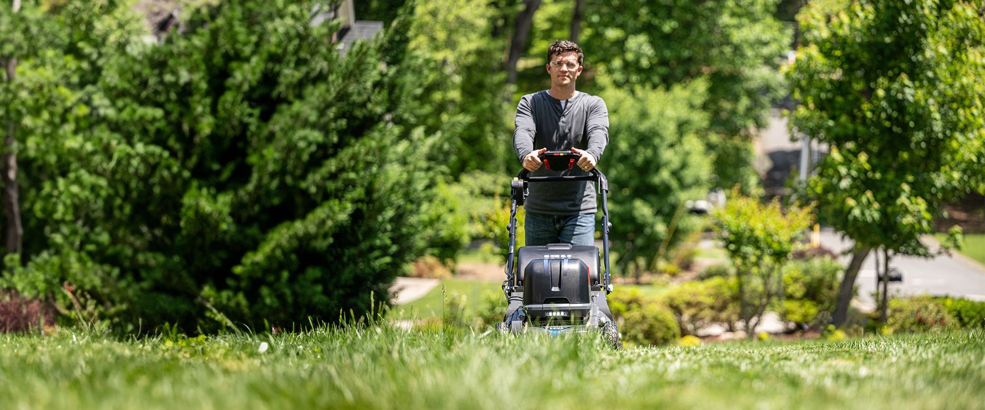 Person Pushing a Mower Along a Grassy Path — Great Lakes Mowers & Chainsaws In Forster, NSW