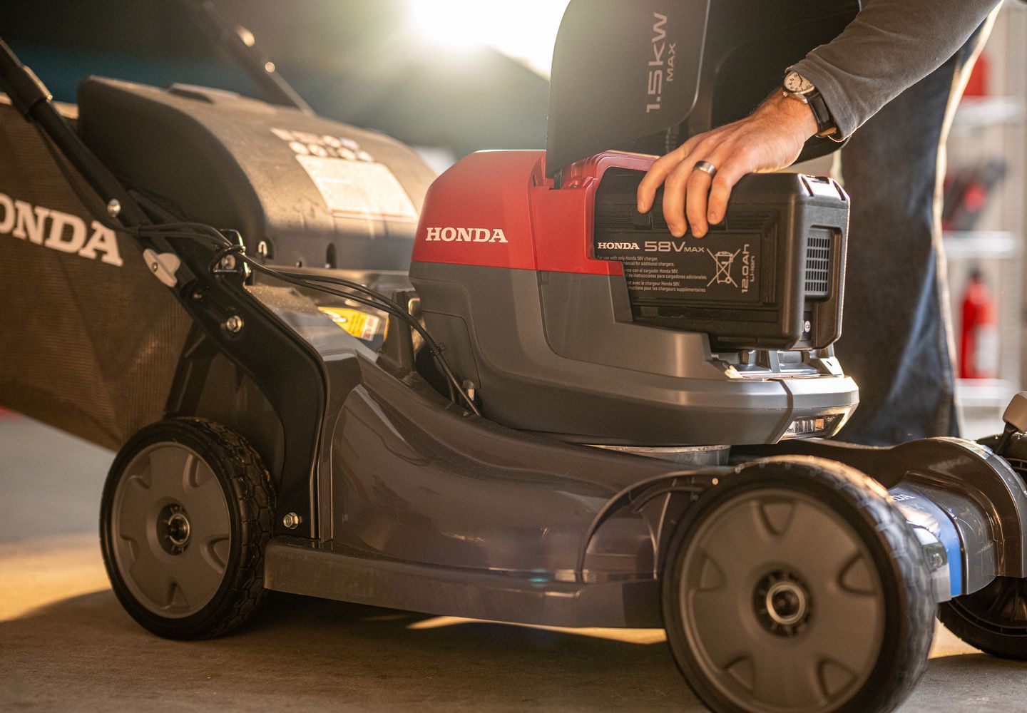 Person Adjusting a Red-and-black Honda Lawn Mower — Great Lakes Mowers & Chainsaws In Smiths Lake, NSW