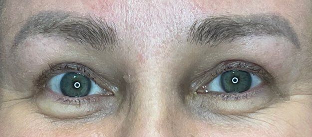Close-up of a person’s blue eyes and eyebrows, looking straight ahead