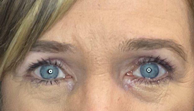 Close-up of blue eyes and eyebrows, showing a neutral expression.
