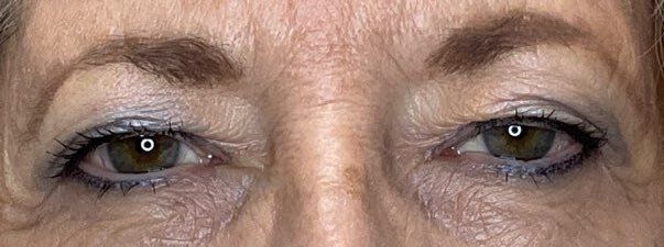 Close-up of a person’s eyes with dark eye makeup and visible wrinkles