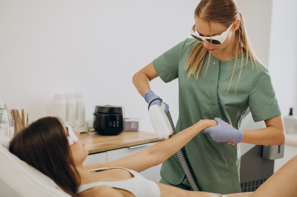 Technician using a handheld device on a reclining client in a bright salon room