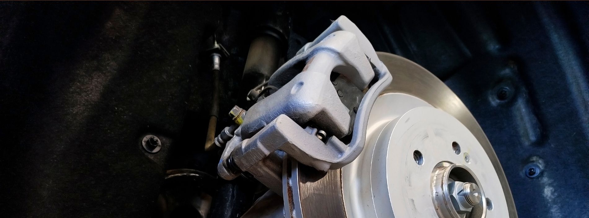 Car brake caliper on a disc brake rotor.