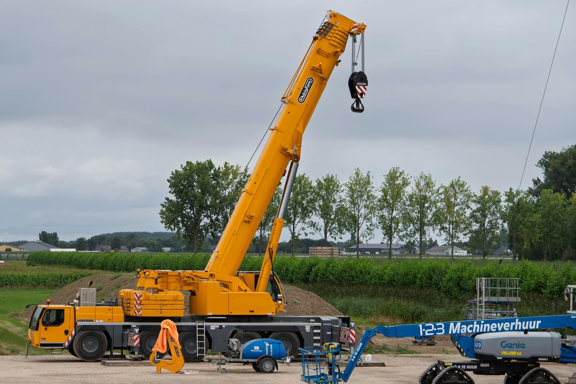 Yellow mobile crane, lifting equipment at a construction site.