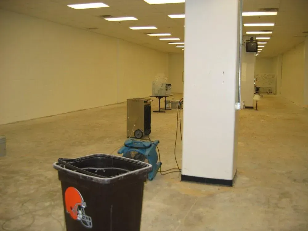 Empty interior, possibly an unfinished space with a trash bin and equipment.