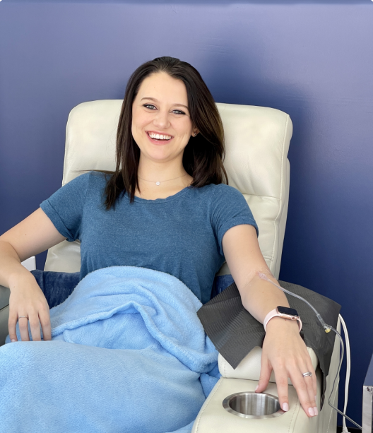 A woman in a blue shirt is sitting in a chair