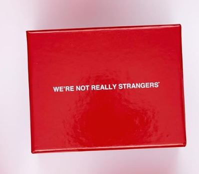 Red glossy box with white text reading “WE’RE NOT REALLY STRANGERS”