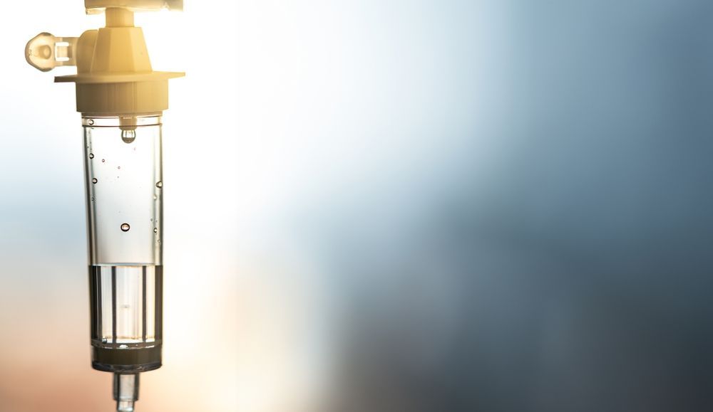 A close up of an iv drip with a drop of liquid coming out of it.