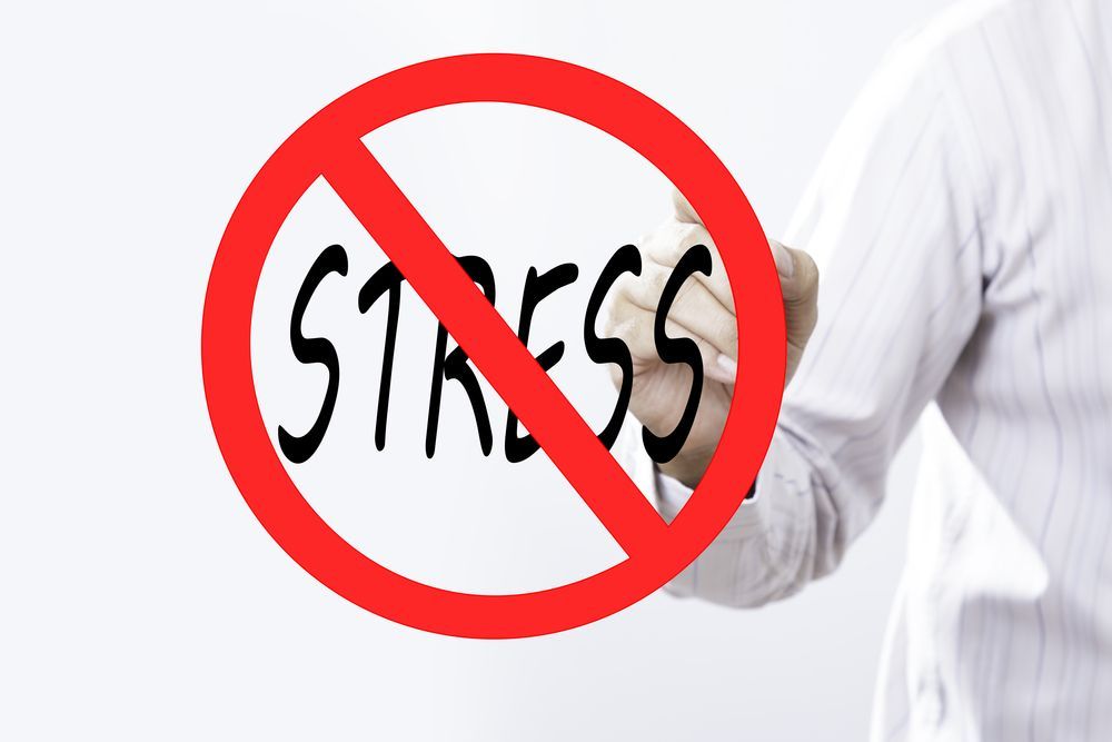 A person is writing the word stress in a red circle