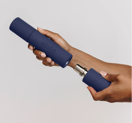 Hands connecting two blue cylindrical device parts against a light background