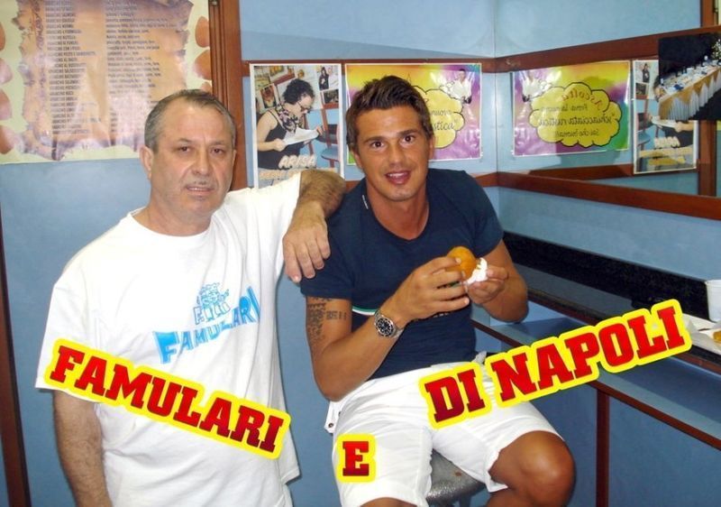 Due uomini in un negozio. Uno tiene in mano del cibo, l'altro lo circonda con un braccio. La scritta recita 
