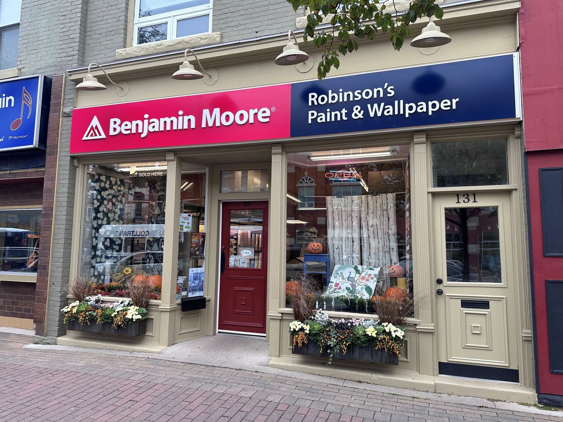 The storefront of Robinson's Paint & Wallpaper, a Benjamin Moore retailer, with brick-patterned sidewalk in foreground.