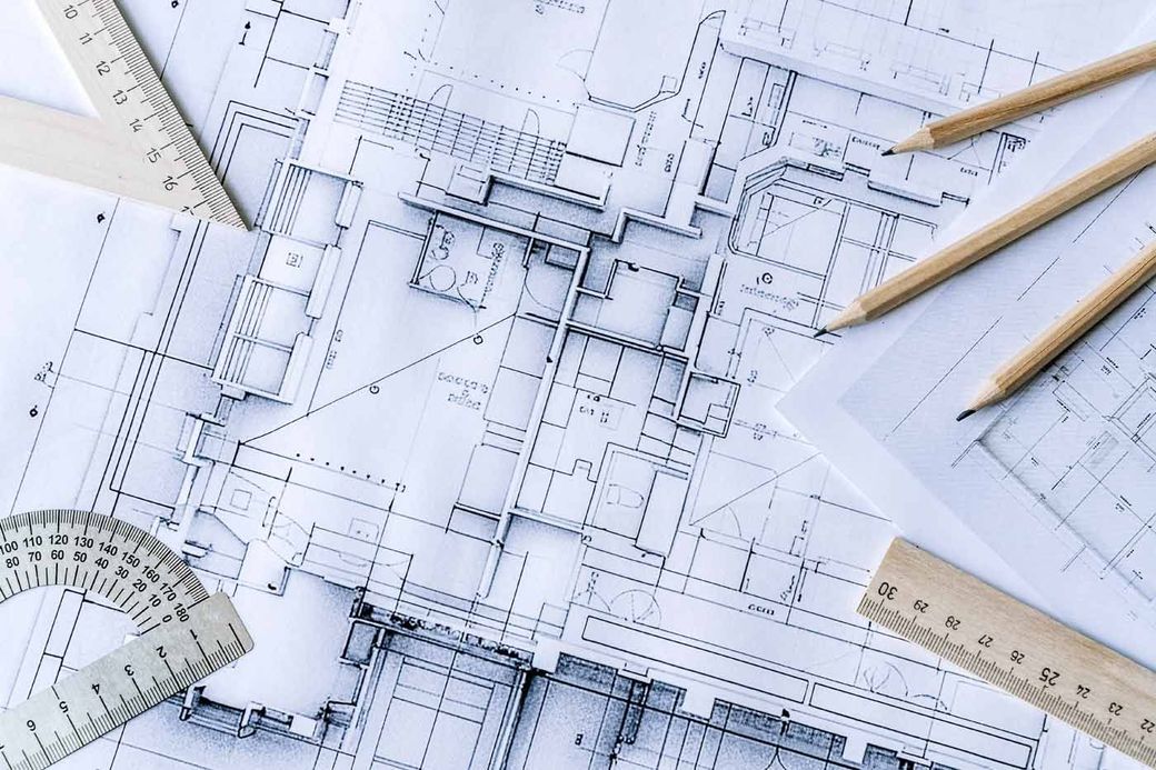 A drawing of a building with a ruler and pencils on it.