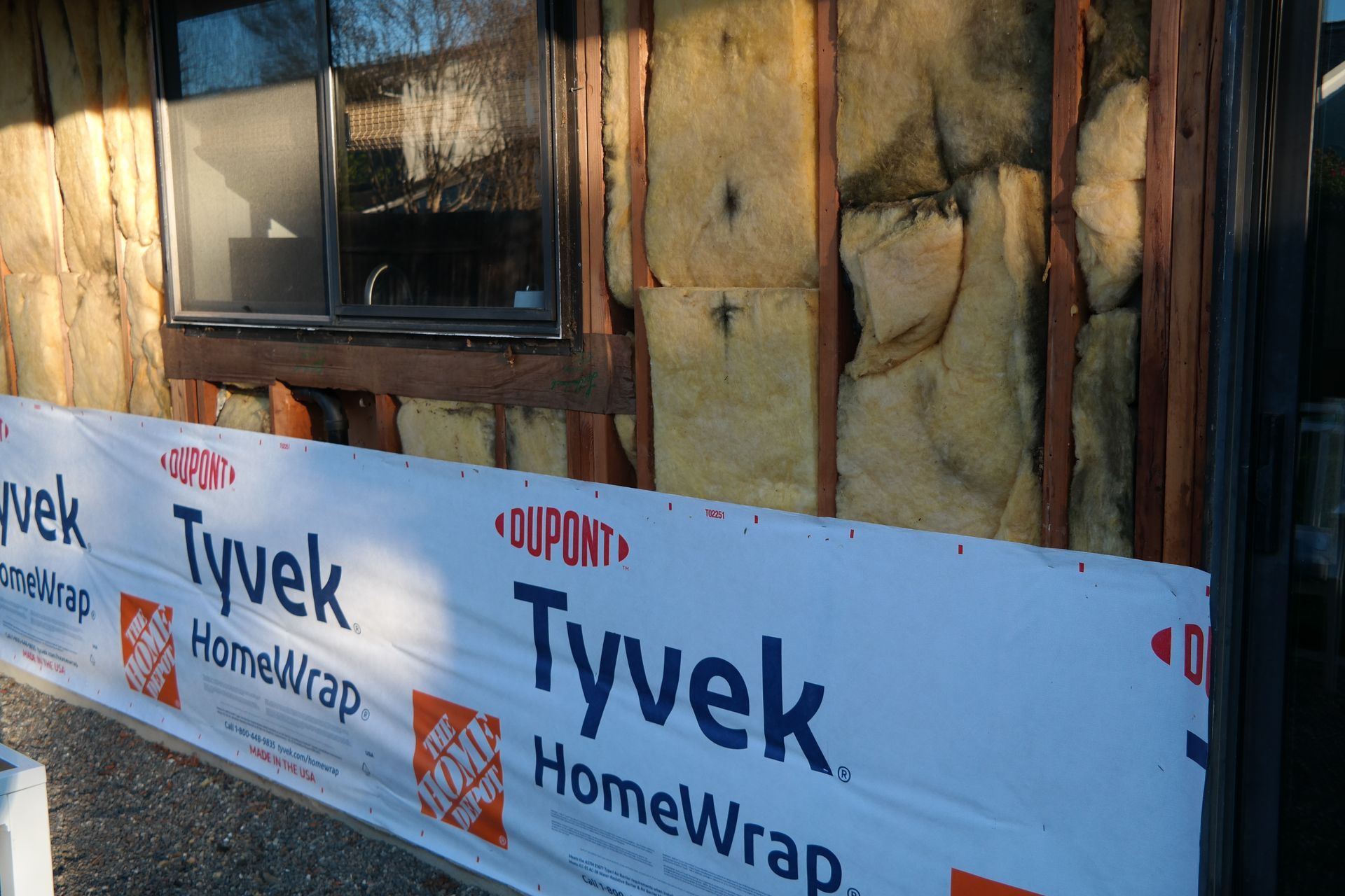Tyvek homewrap is being installed on the side of a house