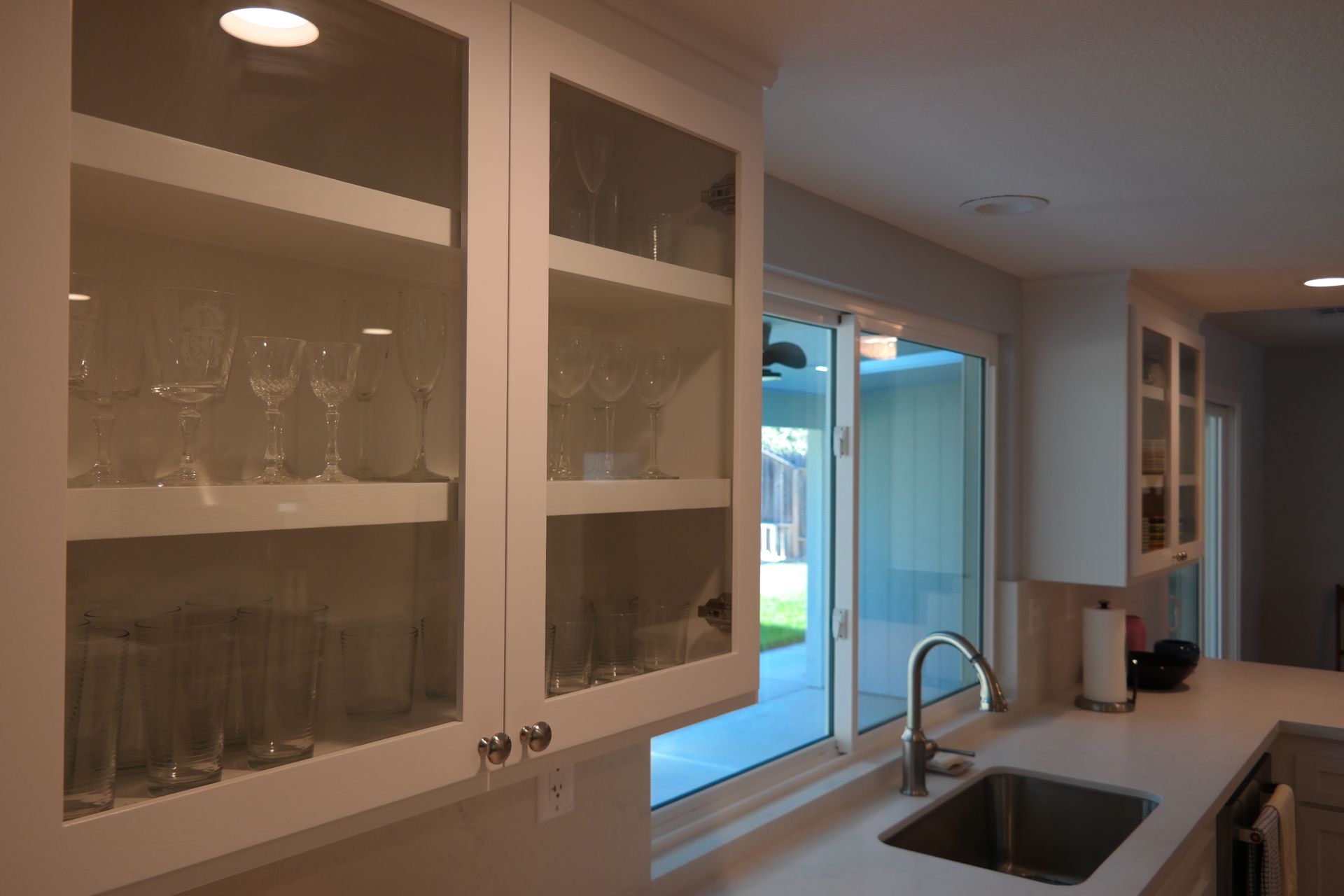 A kitchen with white cabinets and a sink and a window