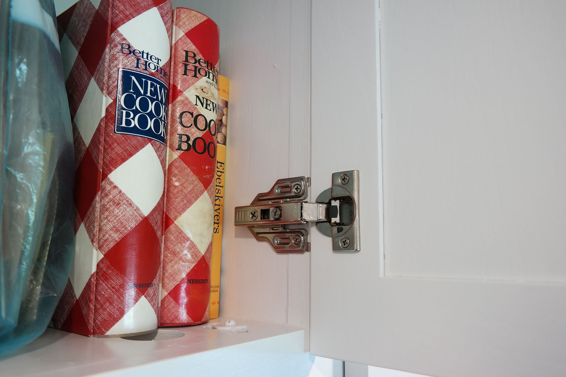 A close up of a cabinet door with two rolls of paper towels on it