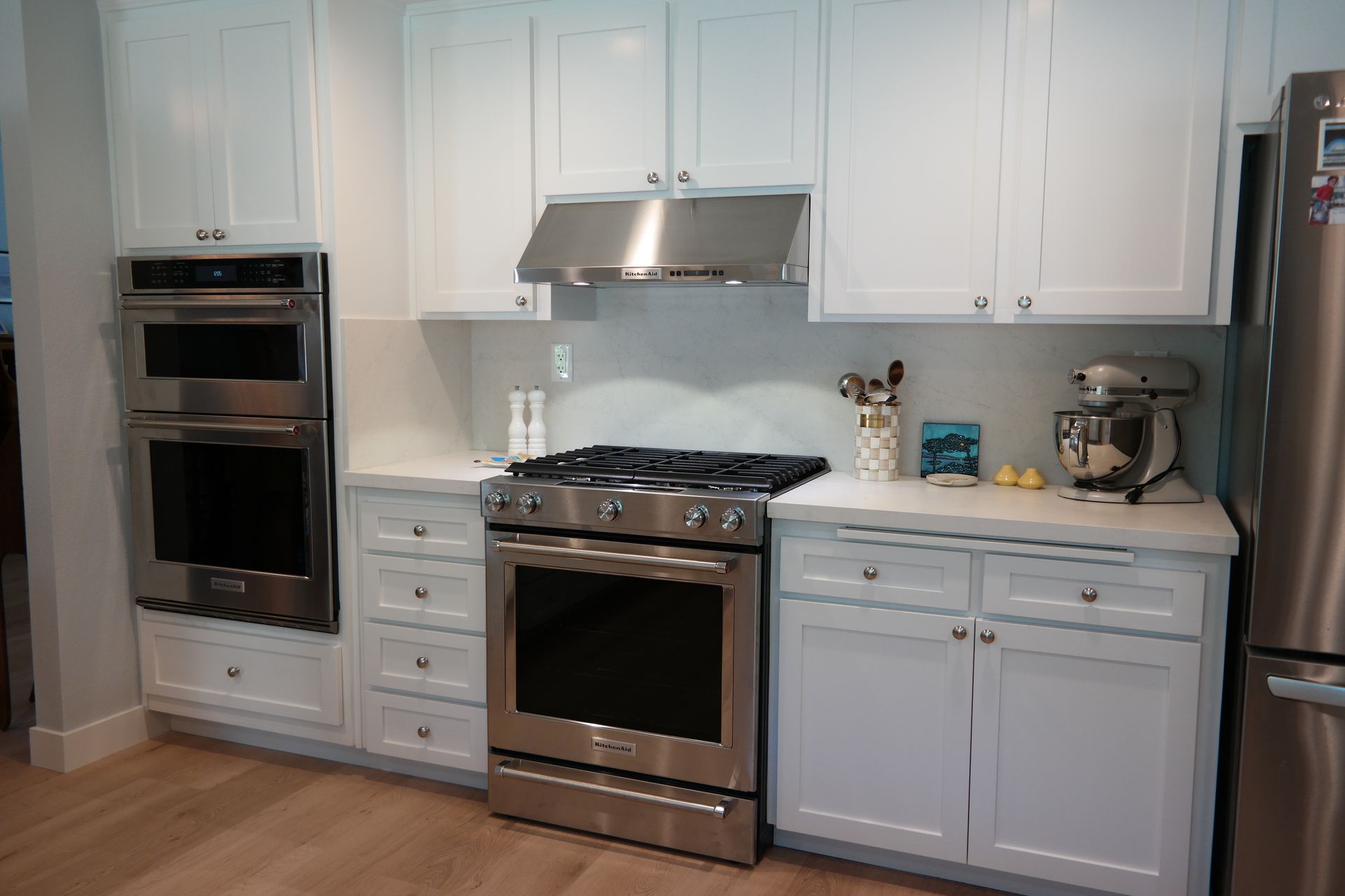 A kitchen with stainless steel appliances and white cabinets.