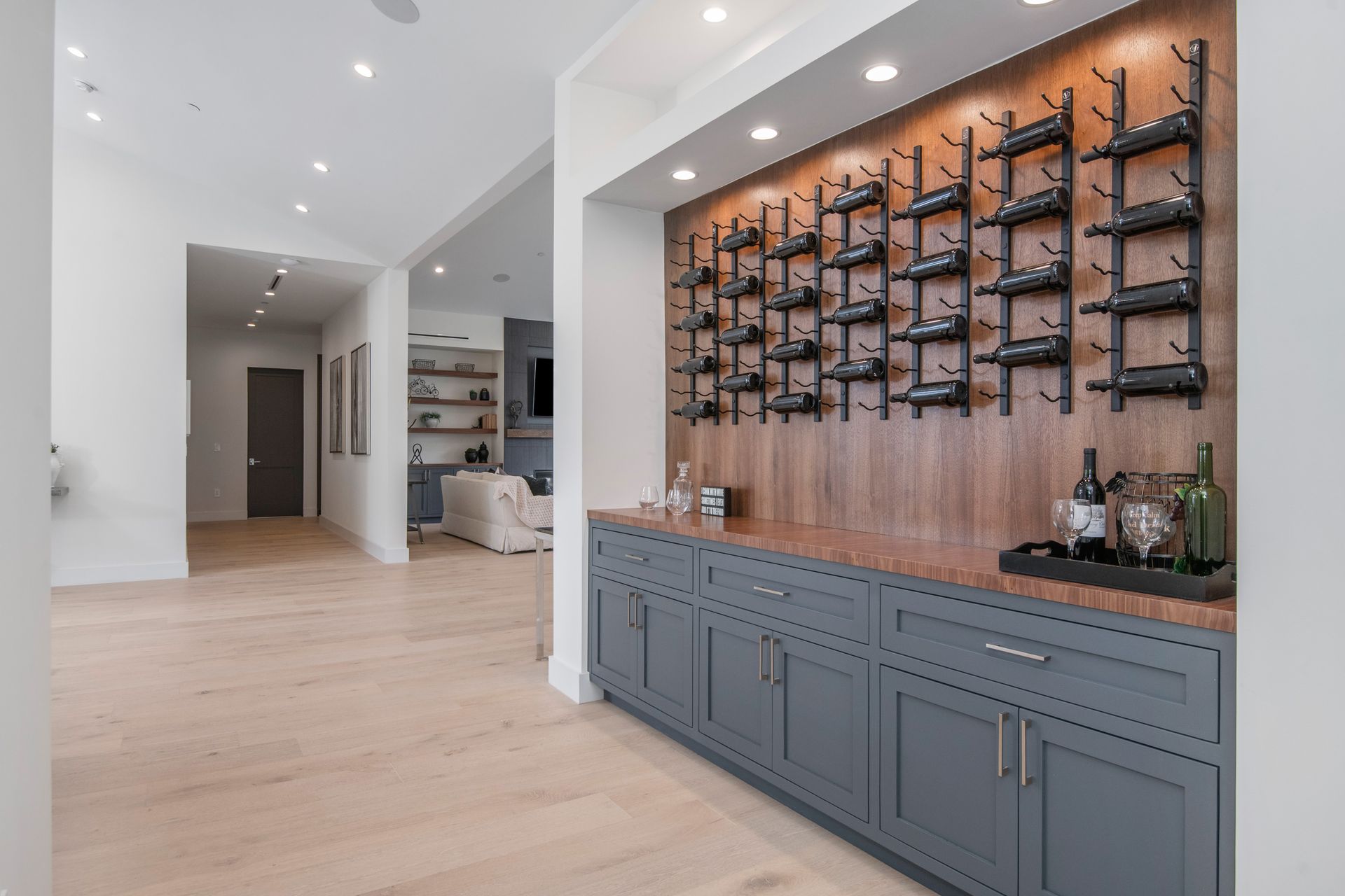 A kitchen with a wine rack on the wall and a bar.