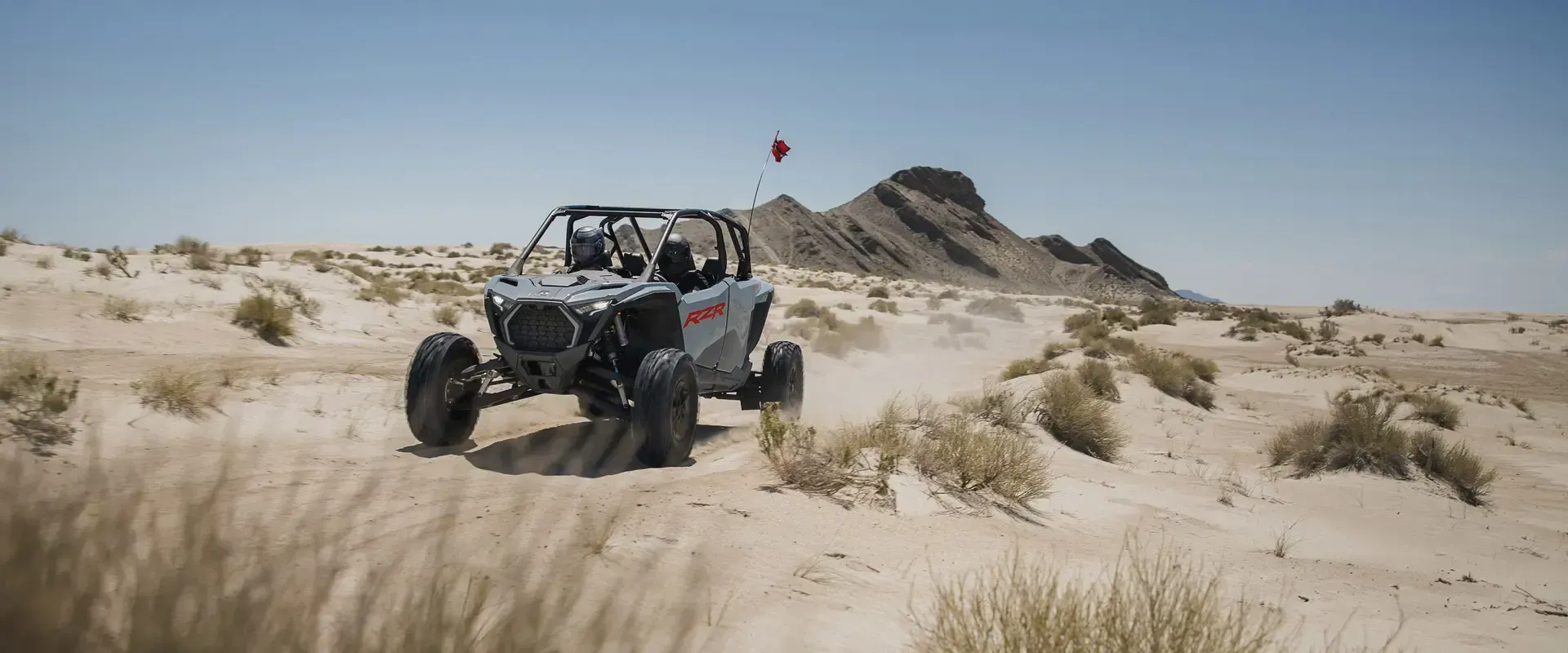 A person is riding a atv in the desert.