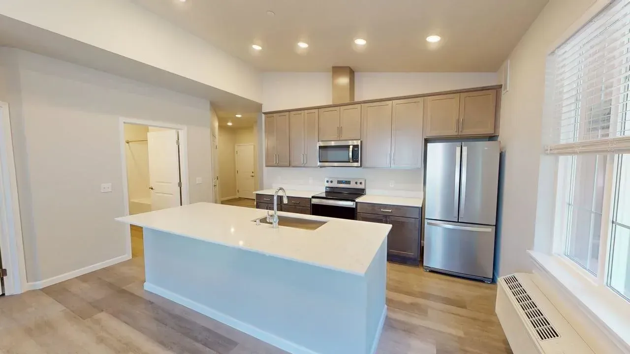 A kitchen with stainless steel appliances and a large island.
