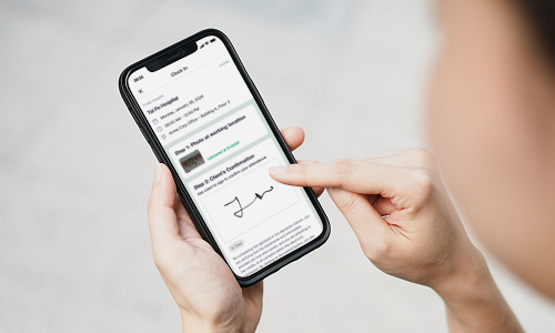 Person using a smartphone with Evercare app to sign a document on the screen.