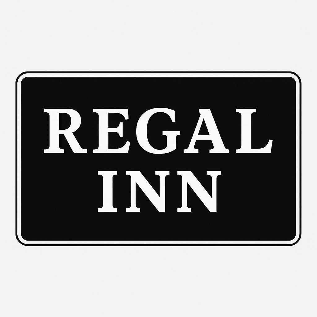 Motel room with bed, lamps, small table, chairs, and dark curtains.