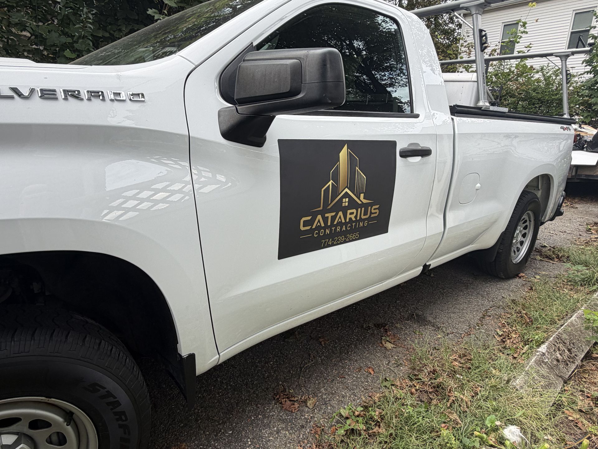 White pickup truck with a black Cataris logo parked on a gravel roadside