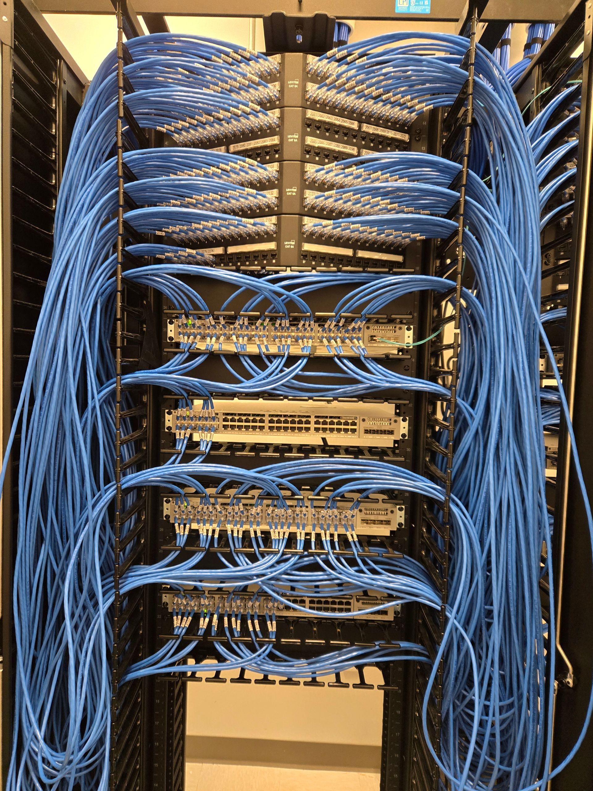 Blue network cables neatly organized in a server rack, connecting various devices.