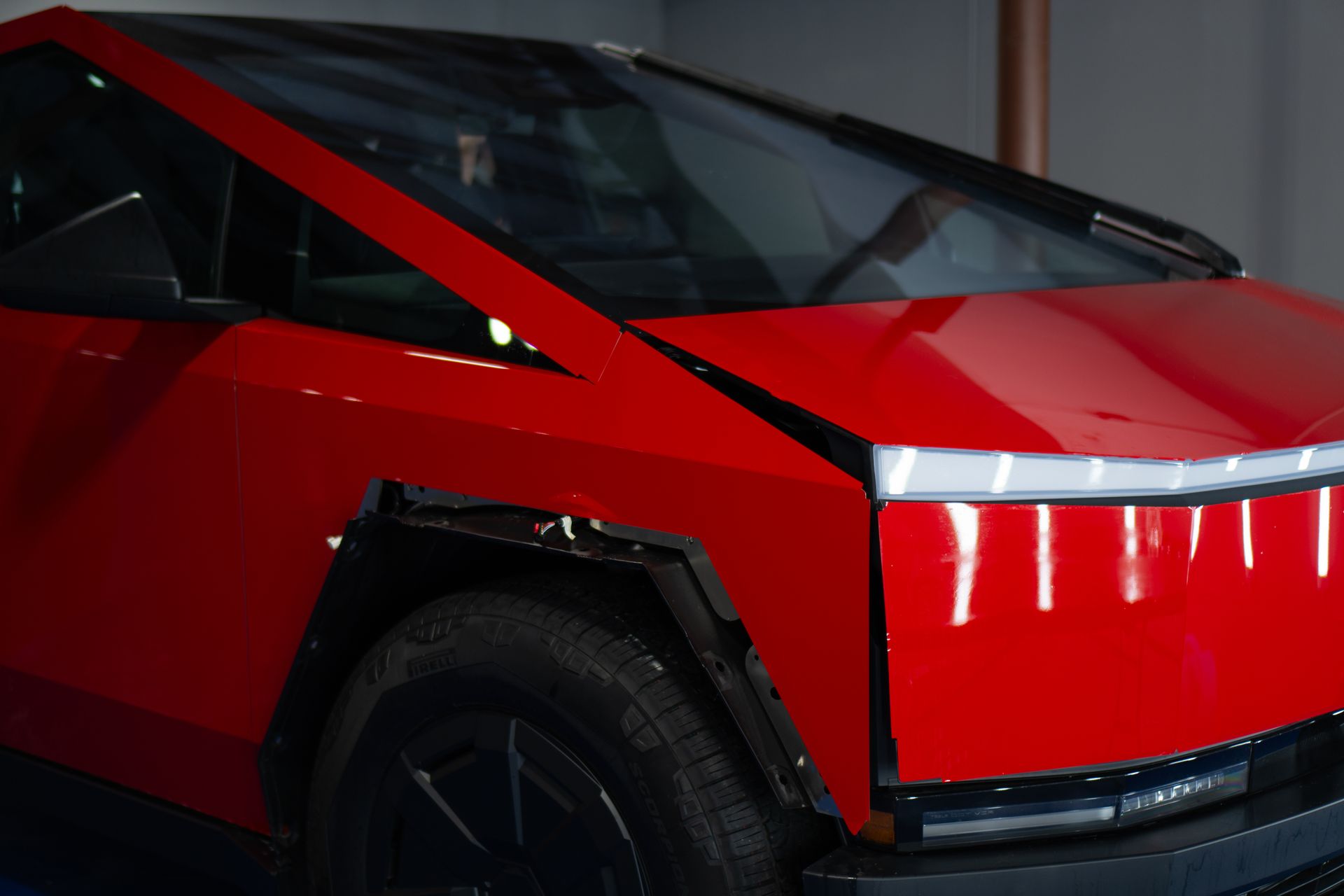 Red Tesla Cybertruck with a futuristic, angular design.