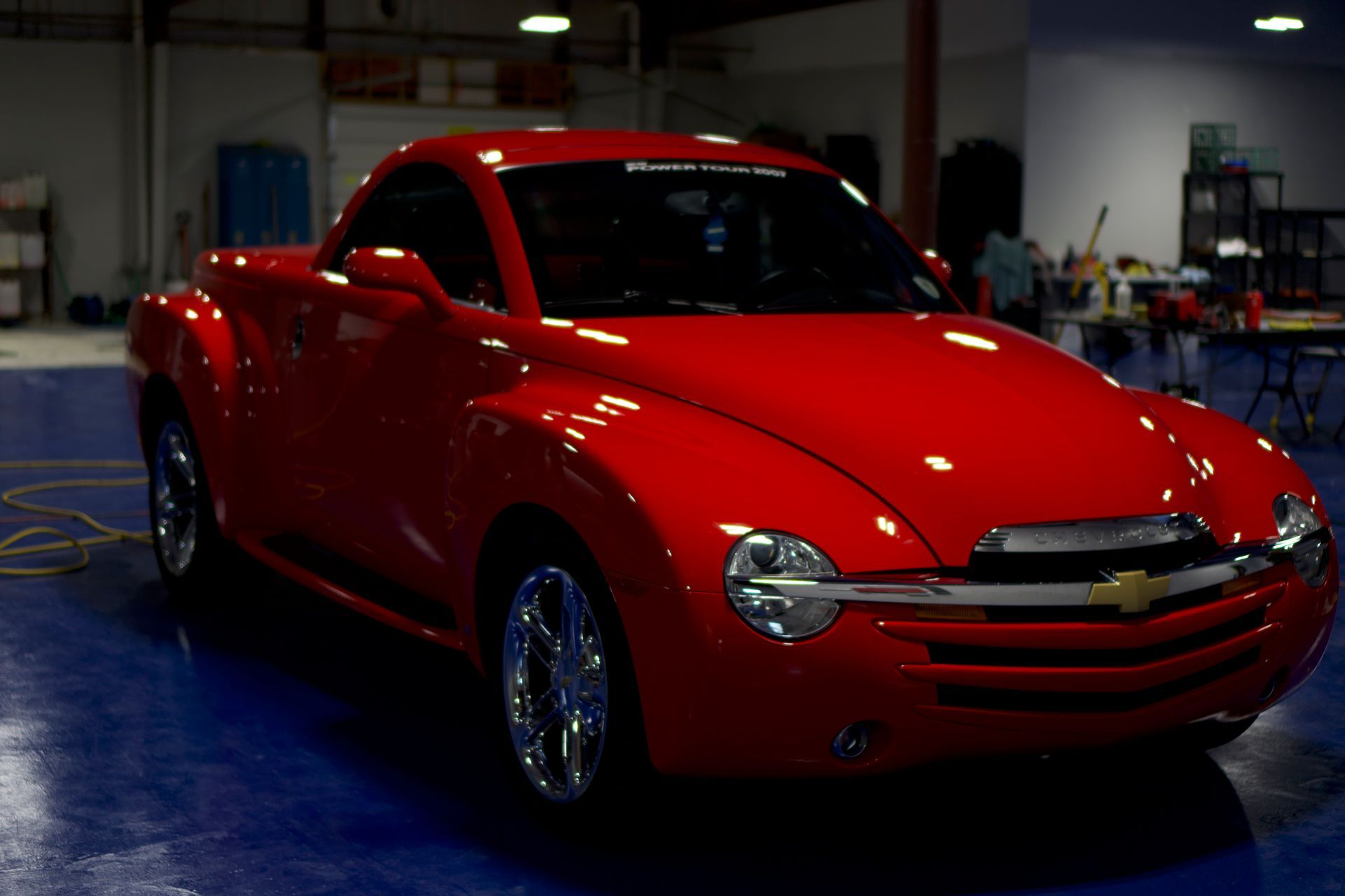 A white ford mustang is being washed in a car wash.