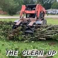 Orange skid steer pushing a pile of branches on a lawn, with “THE CLEAN UP” text below