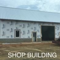 Partially built shop building with metal roof and unfinished walls under construction