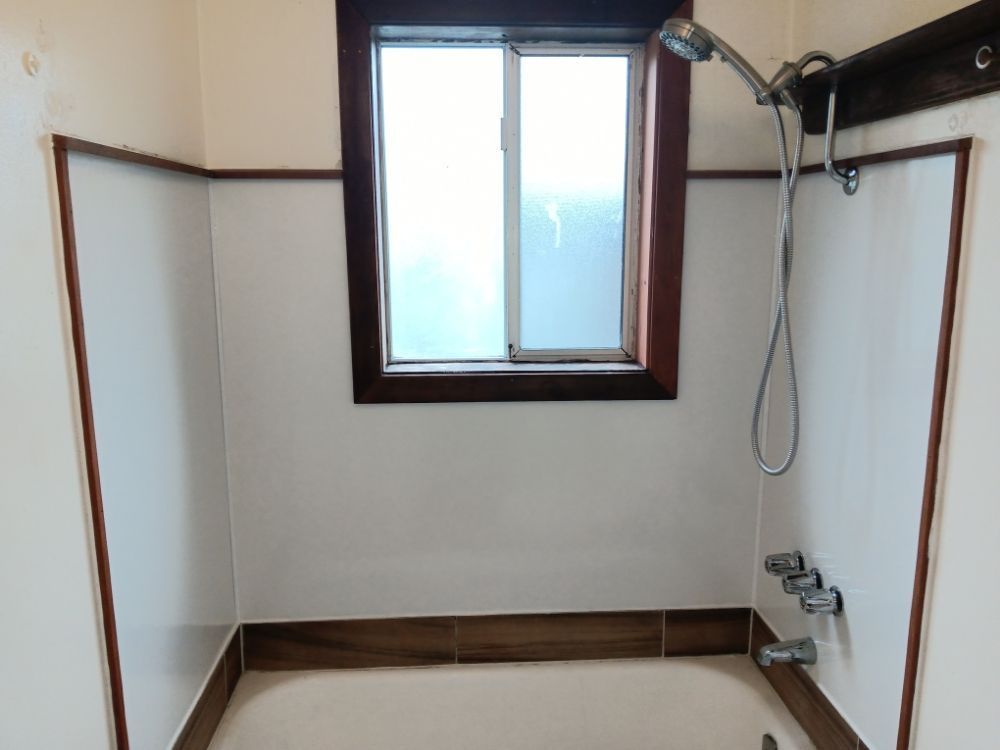 A bathroom with a bathtub and a shower head