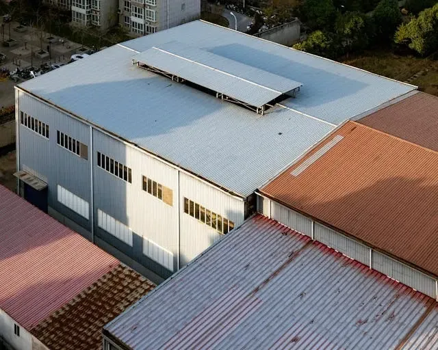 Aerial view of a large industrial warehouse with metal roofing panels and commercial building struct