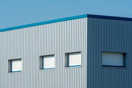 Aerial view of a large industrial warehouse with metal roofing panels and commercial building structure.