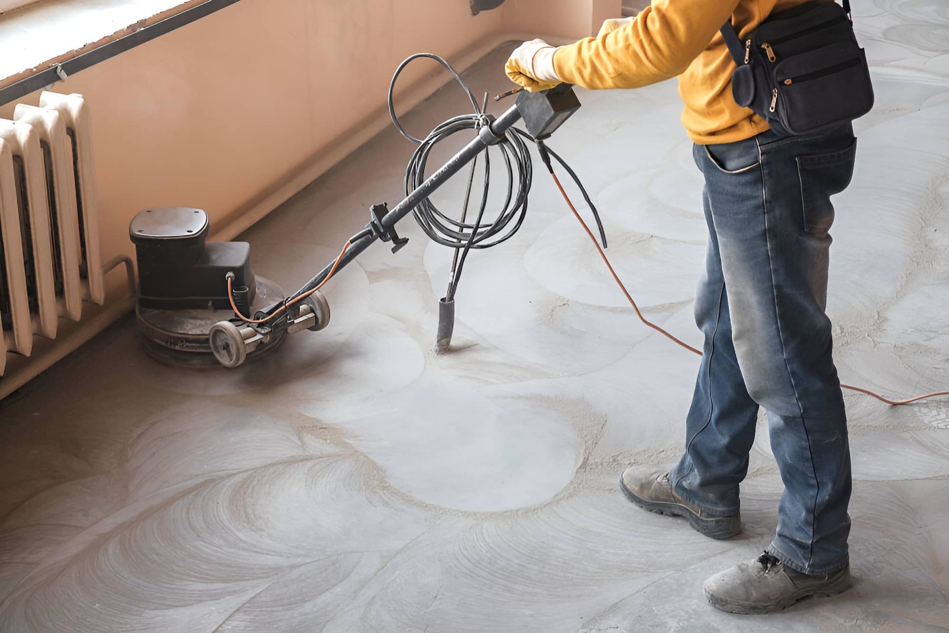 A Man Is Using A Machine To Polish A Concrete Floor — JGA Concreting Pty Ltd In Berrimah, NT