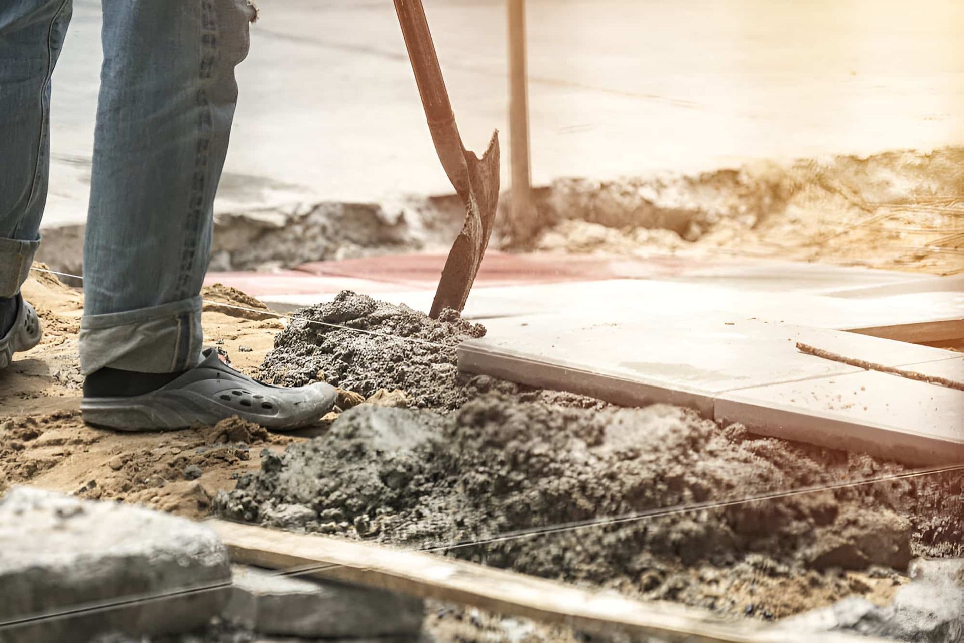 A Man Is Digging In The Dirt With A Shovel — JGA Concreting Pty Ltd In Berrimah, NT