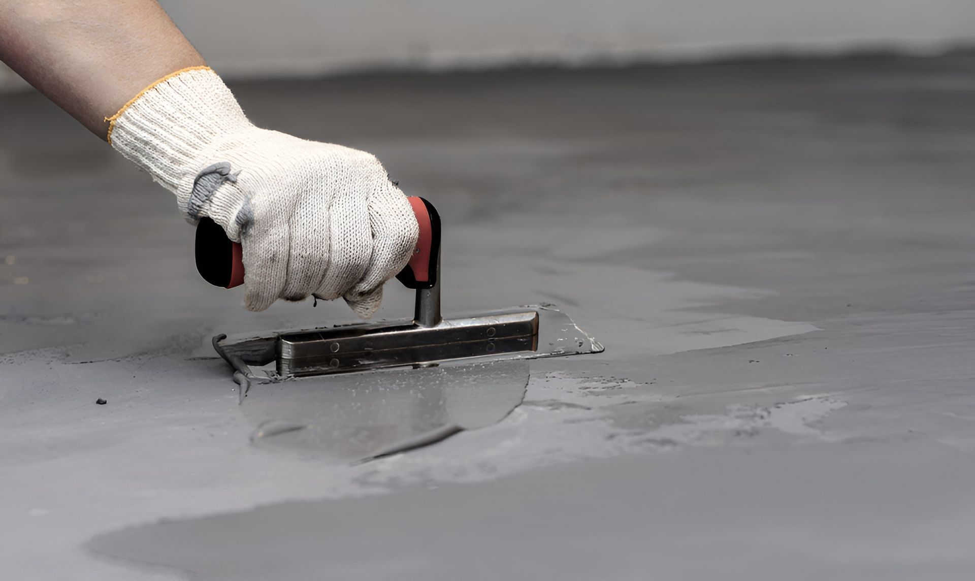 A Person Is Using A Trowel On A Concrete Floor — JGA Concreting Pty Ltd In Berrimah, NT