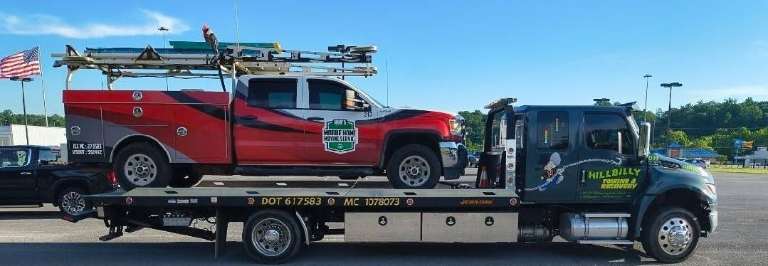 Tow truck loading a white sedan in a parking lot under a bright sky