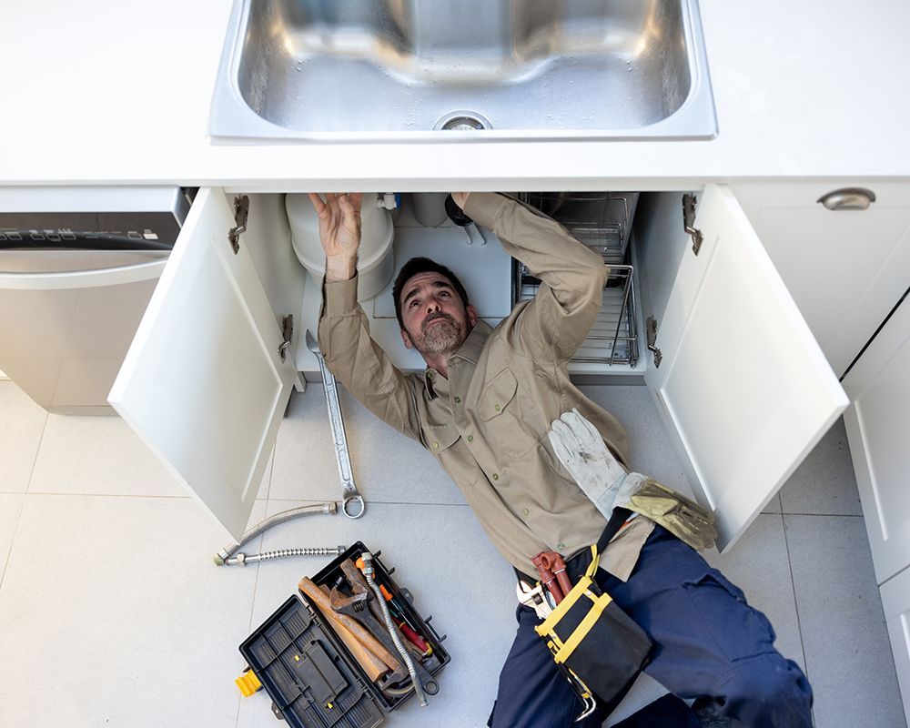 Plumber Fixing Under The Sink — Danville, AL — Express Rooter & Lamco Plumbing