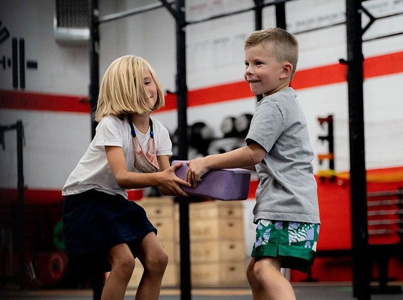 Two kids passing a block 