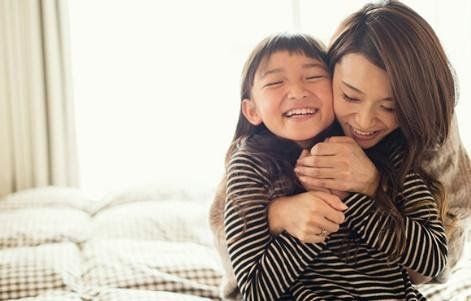 A mother hugging her daughter