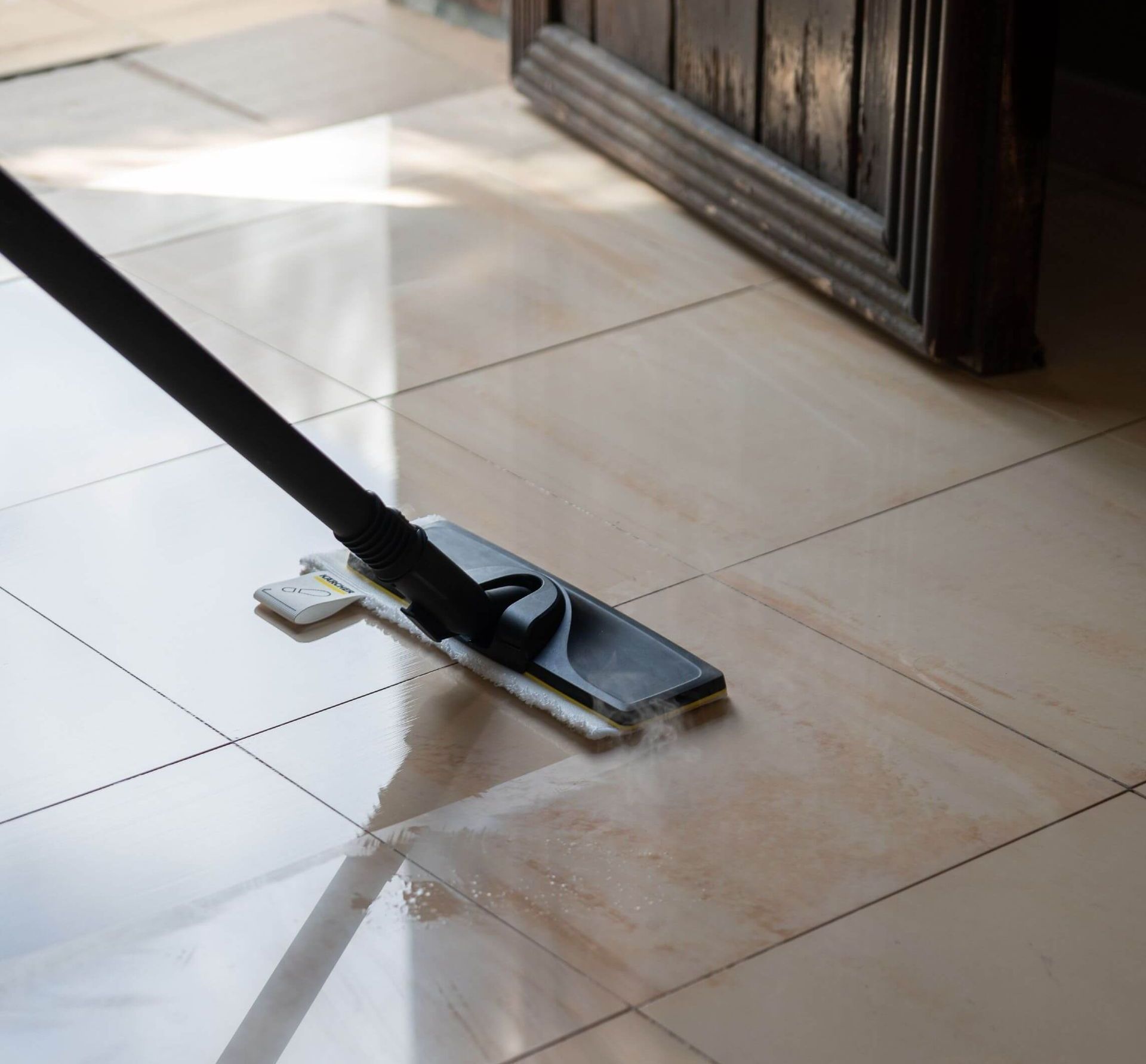 Se está utilizando un trapeador para limpiar un piso de baldosas.