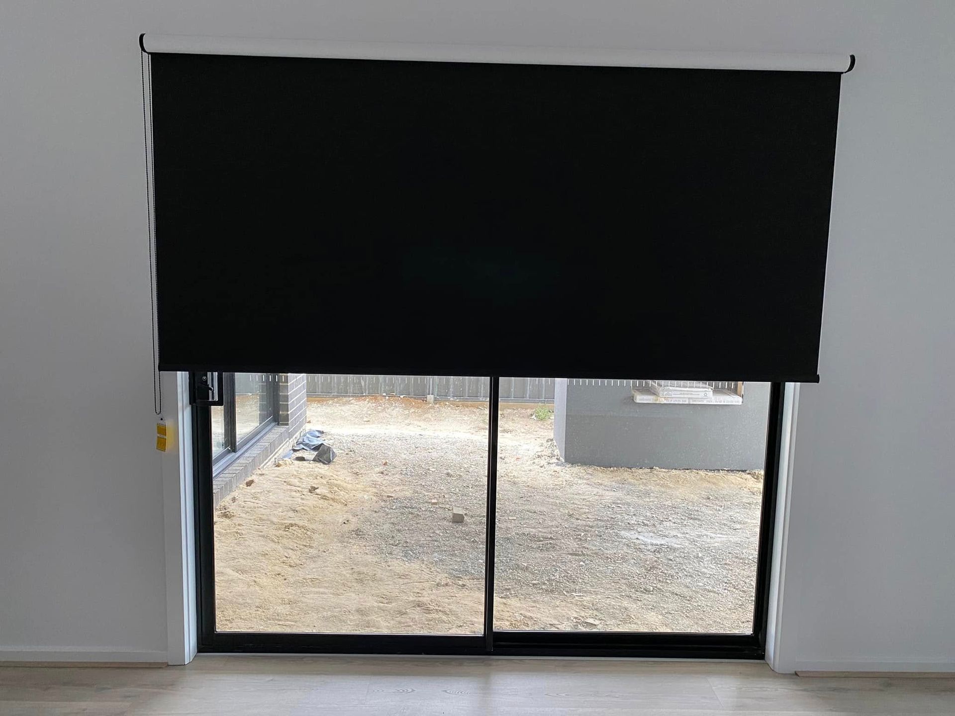 A Sliding Glass Door With A Black Blind On It — Night & Day Blinds and Awnings in Pakenham, VIC