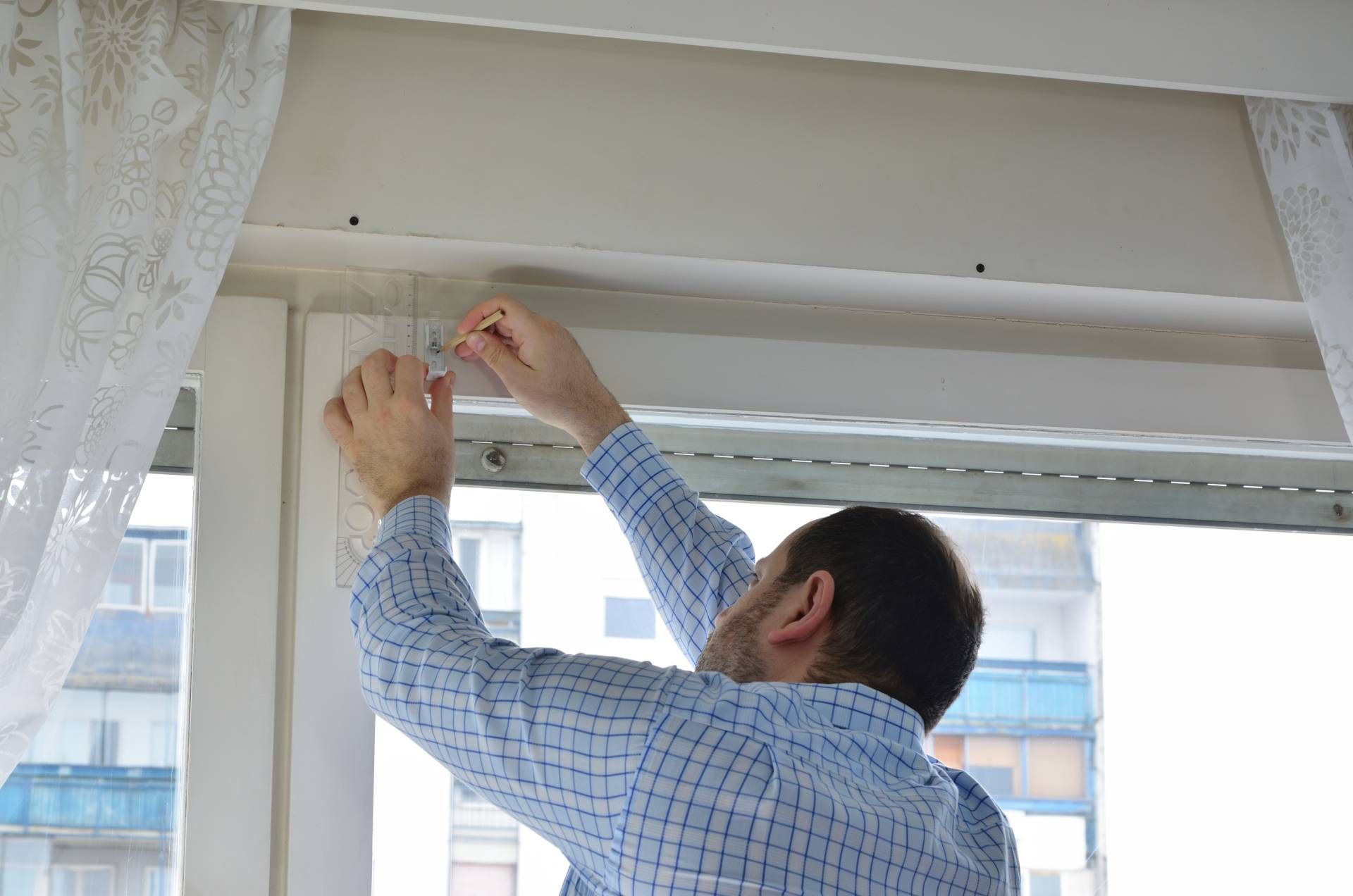 A window treatment installer at work helping with a shade installation near Baltimore.