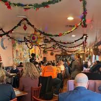 Decorated indoor gathering with seated audience in a festively decorated room